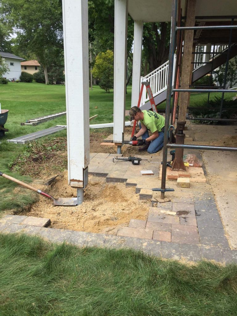 Removal of paver patio to expose failed concrete footings.