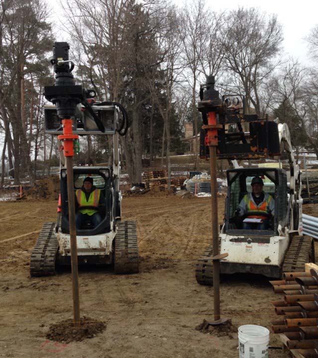 Installing helical piers two at a time for a new home foundation.